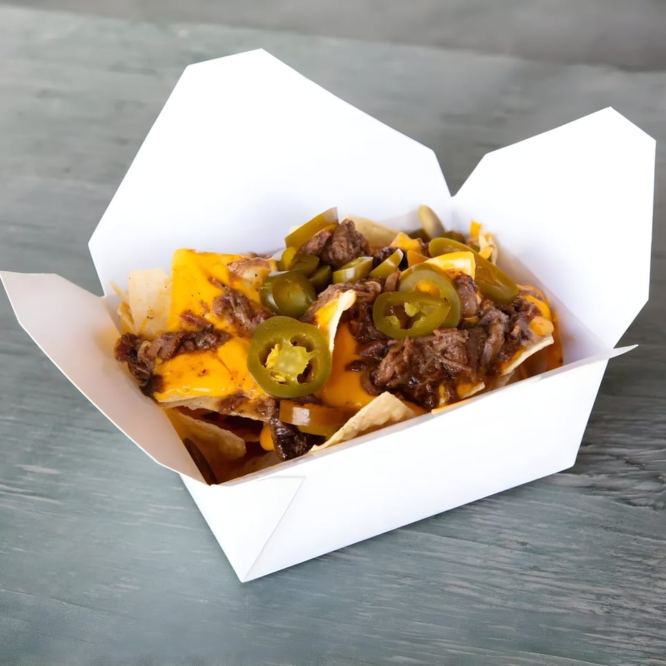 Mosito's BBQ nachos with melted cheese, shredded beef, and sliced jalapeños in a white takeout box.